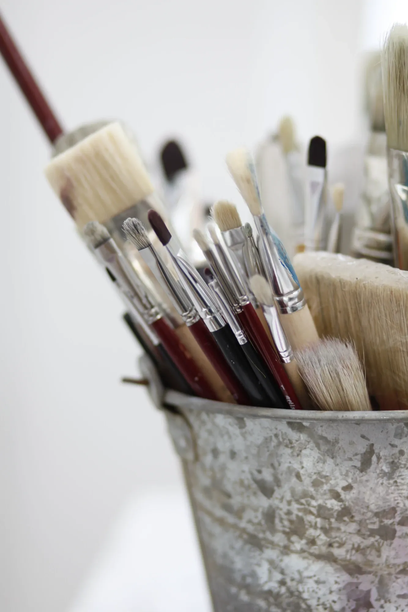 Pinsel in einem Zinkeimer im Atelier
